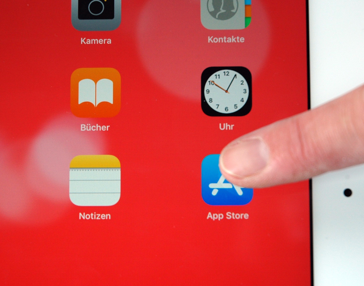 Das Symbolbild zeigt einen Ausschnitt eines Tablets mit dem Icon eines App-Stores, auf den ein Finger zeigt.